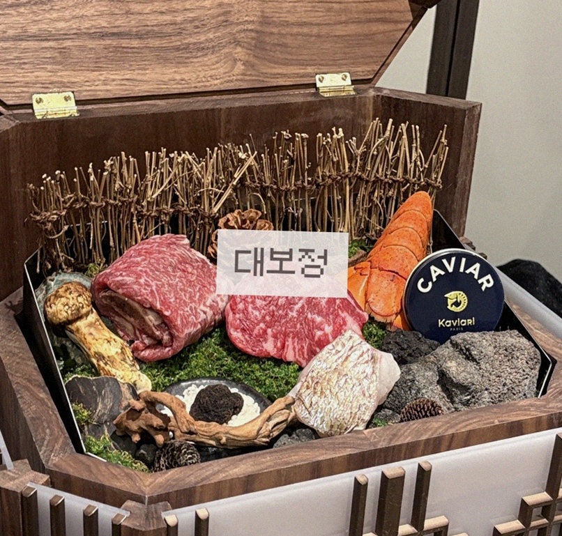 DAEBOJUNG Yeouido · the signature Hanwoo showing — marbled beef cuts and caviar presented in a display chest