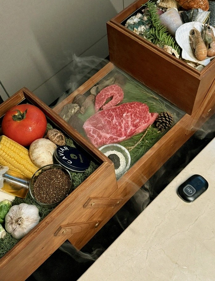 WOOARA Yeouido · the signature Hanwoo showing — marbled beef cuts and caviar presented in a display chest